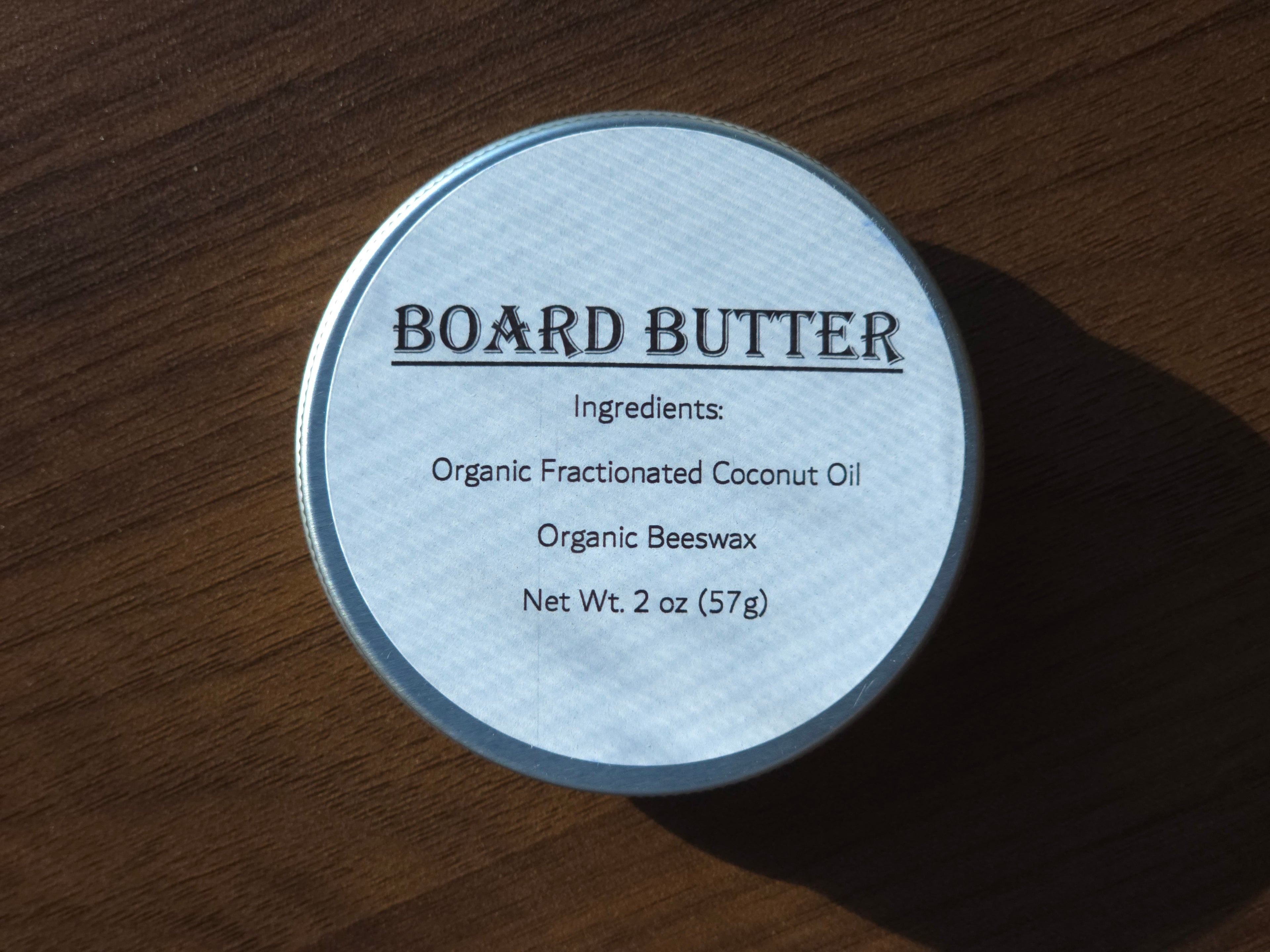 Container of ReDieming Creations board butter cutting board conditioner with label on a wooden surface